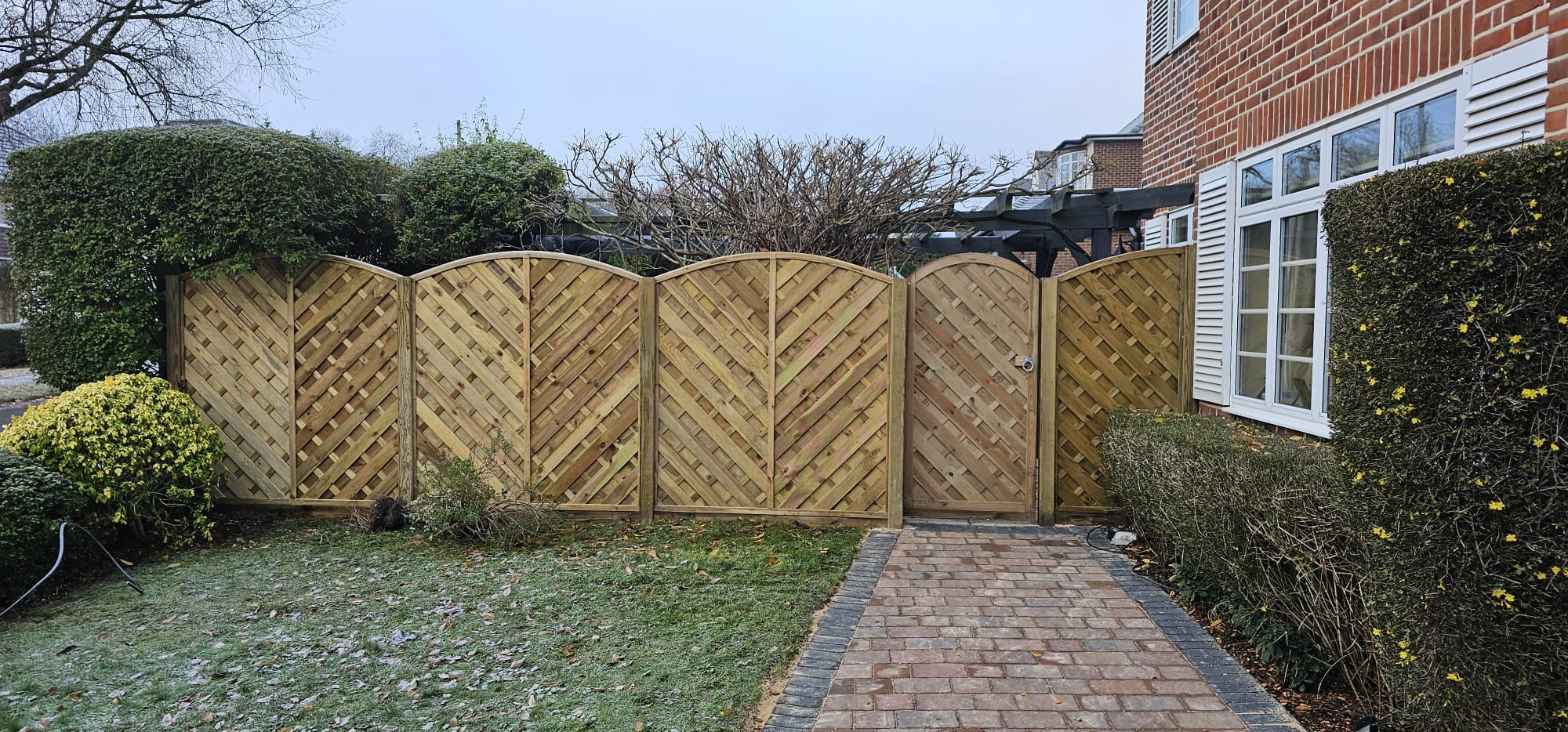 An image showing new horizontal design fence panels installed along with a gate to match the style.